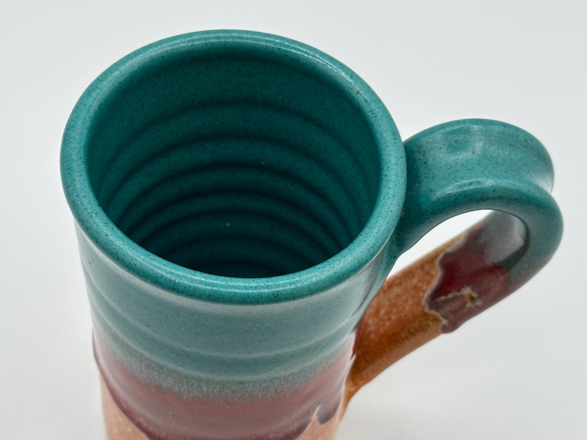 Rustic Stoneware Mug: Handcrafted Ceramic Coffee Cup with Teal, Red & Brown Drip Glaze